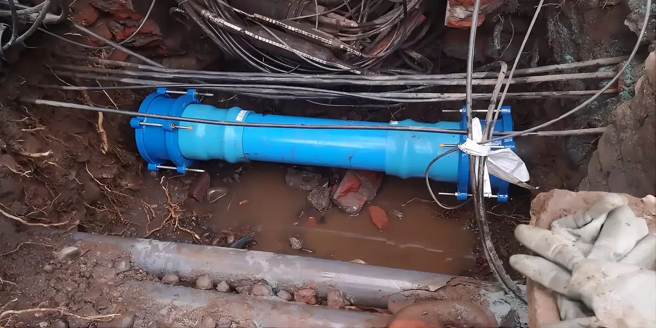 Técnico Teknifugas reparando una matriz de agua con manguito de reparación